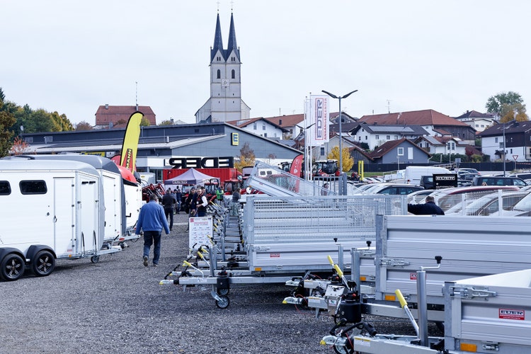 Blick auf EDER Anhängercenter auf der Kirchweihausstellung 2025 in Tuntenhausen mit Kirche im Hintergrund.