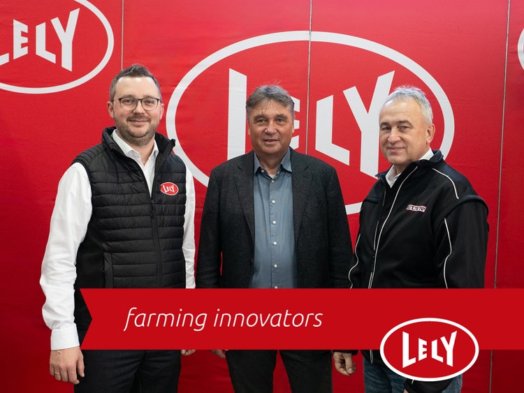 Franz-Georg Wastl, Peter Eder und Georg Pfeilschifter vor einer Lely Wand mit einer Lely "Farming Innovators" Fahne im Bild