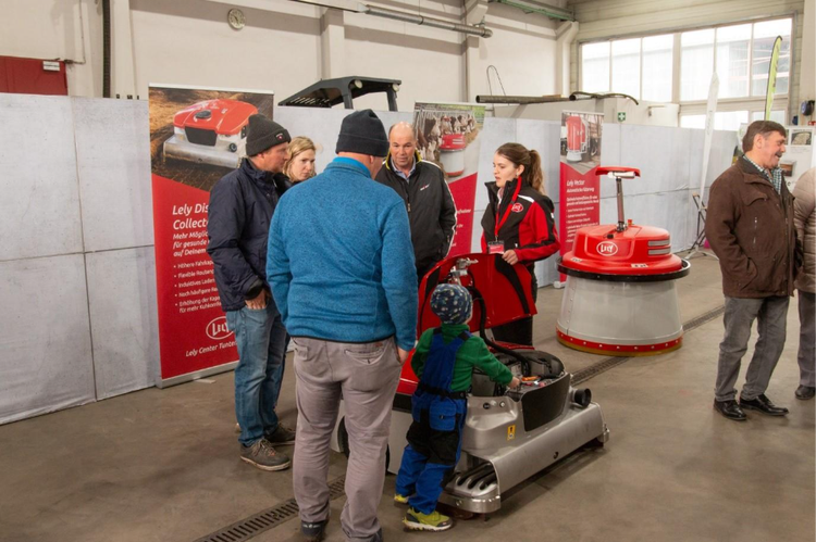 Foto mit Besuchern, die sich am Lely Stand informieren.