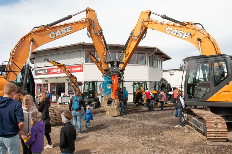 Besucher bestaunen den Case Raupenbagger mit Meisselaufsatz