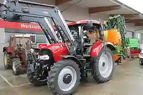 Bild eines roten Case Traktors bei der Übergabe an Kunden