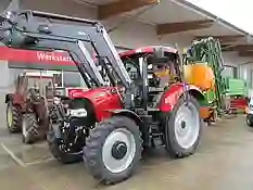 Bild eines roten Case Traktors bei der Übergabe an Kunden
